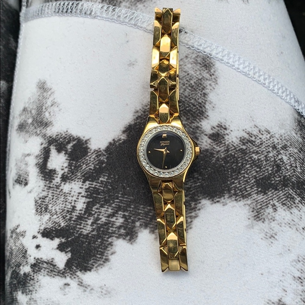 Gold citizen watch with diamonds around face.